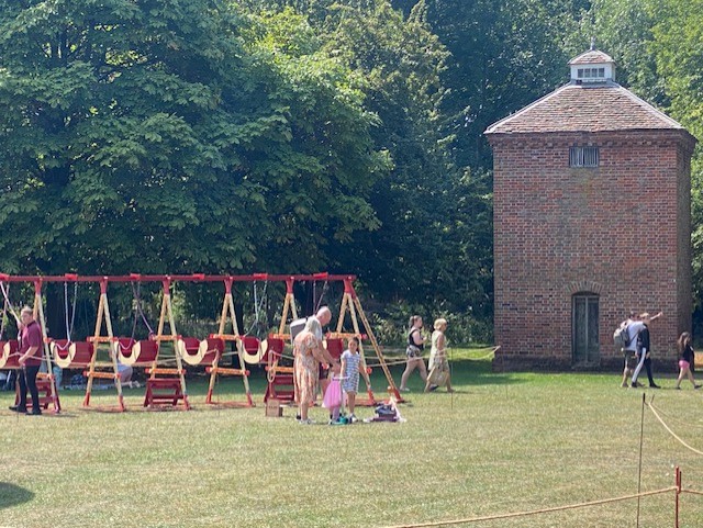 swing boats on the lawn with dove cote building