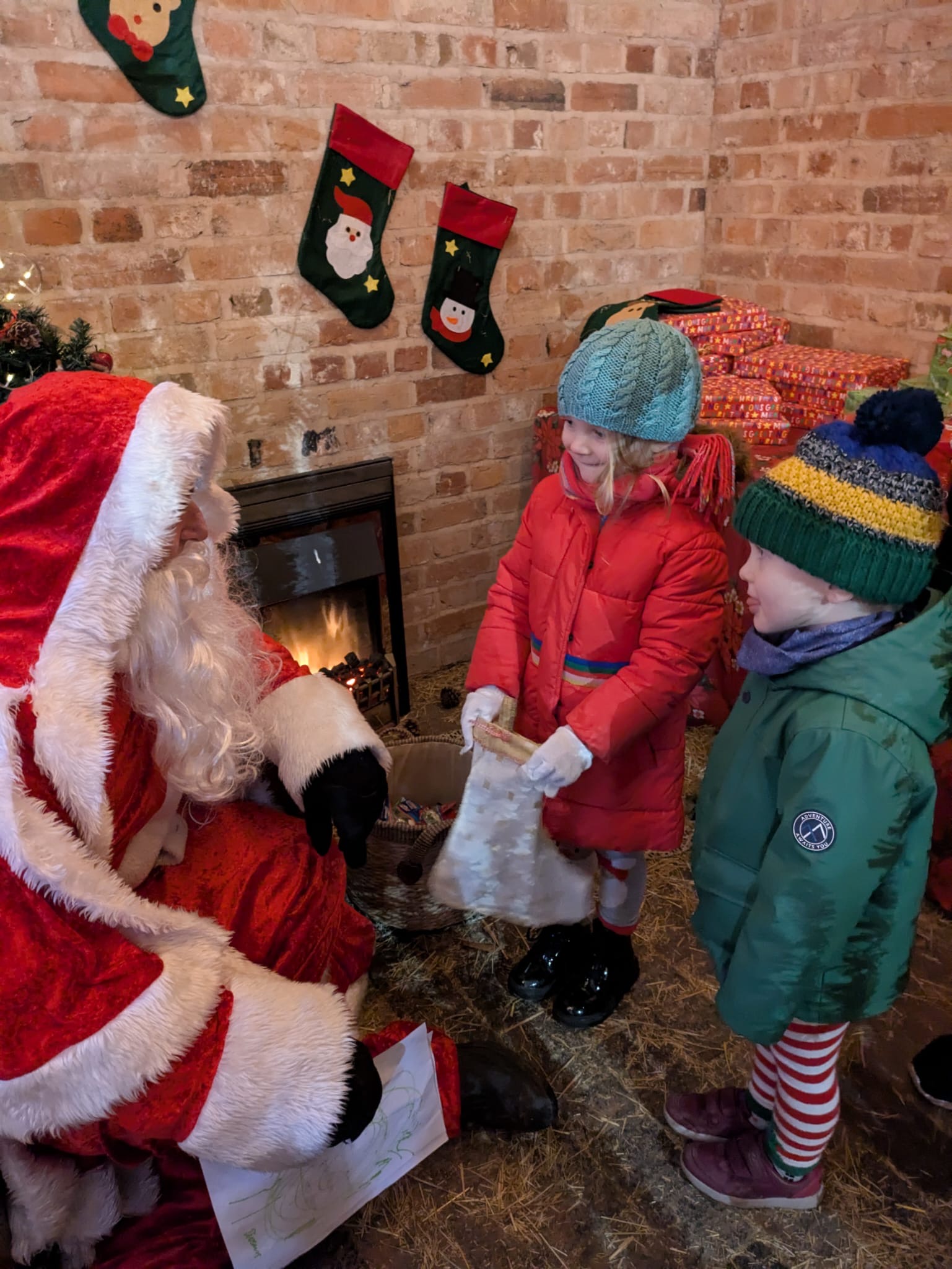 Santa with two smiling children all dressed up for winter