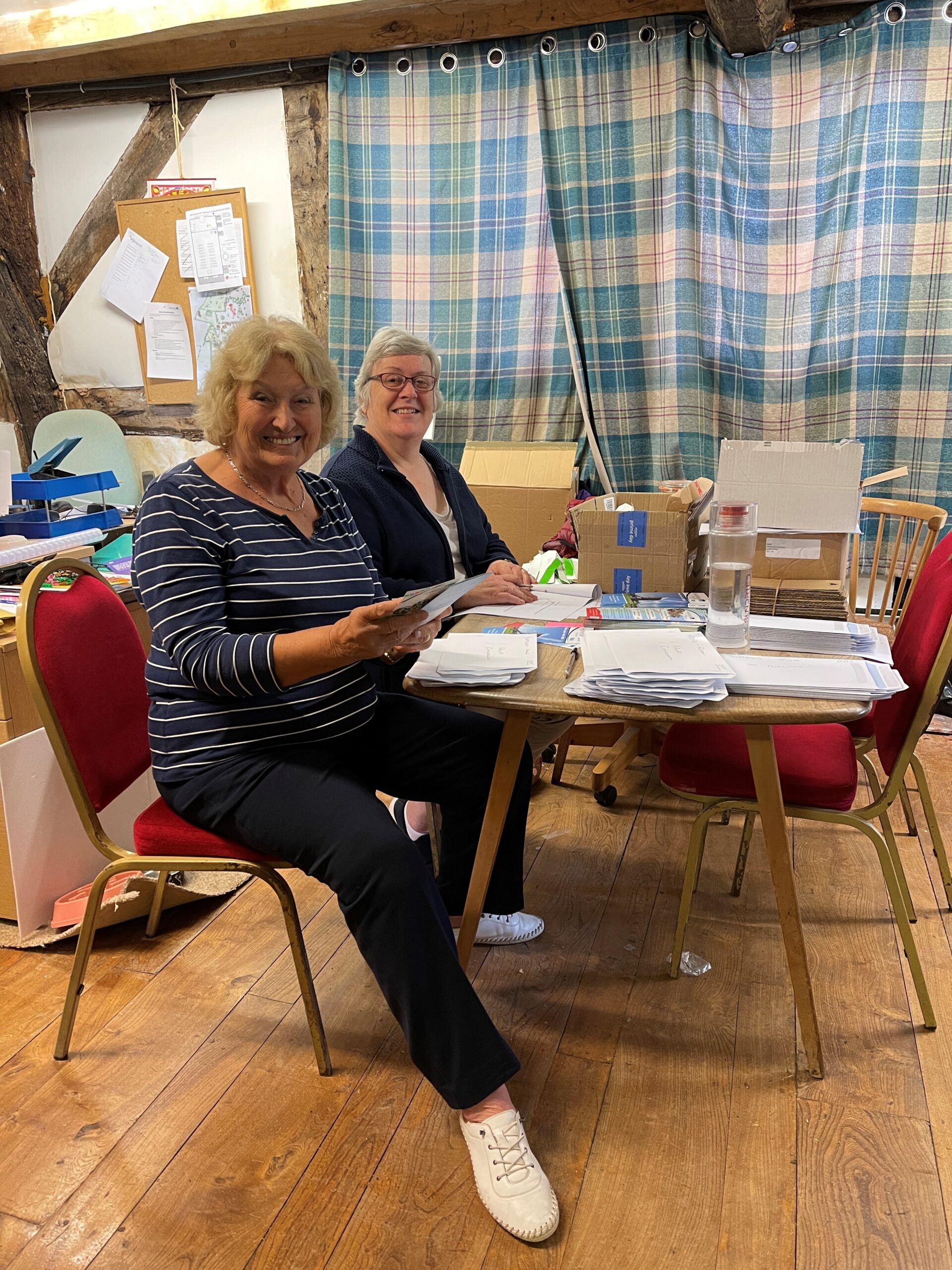 two women at table smiling doing paper work